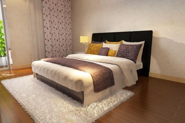 Image of the bed with a cozy blanket and pillow.