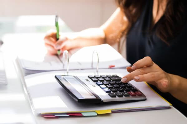 Image of the lady calculating the estimated total rent and writing it down for the record.