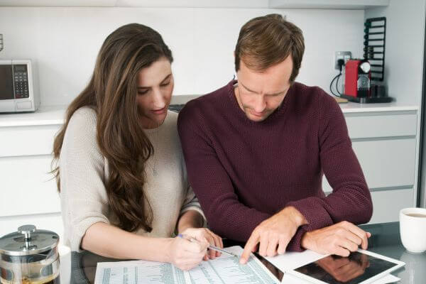 Image of the couple setting their financial plan to prevent shortage and one of the examples of preparing the unexpected costs.