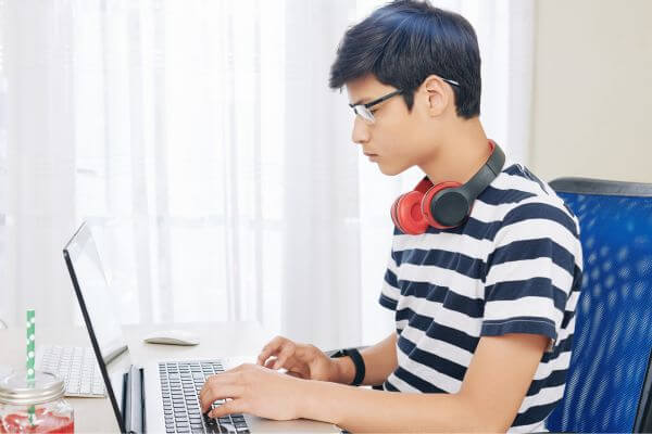 Image of a teenage boy doing website testing as his side hustle to make money.