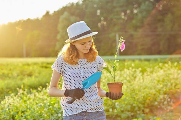 Image of a teen doing a gardening errand to earn money.