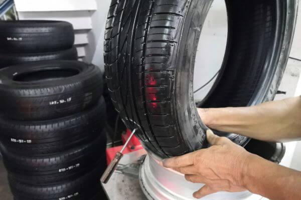 Picture of a tire patching done by an expert and breaking down the costing of tire patching.