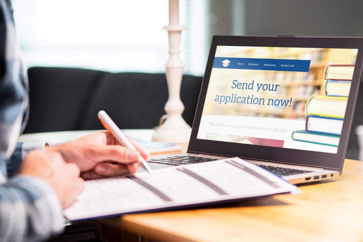 The image of the students shows of writing a scholarship application form.