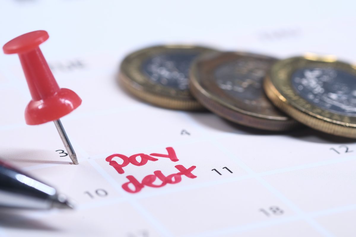 Picture of coins and a calendar with pay debt note.