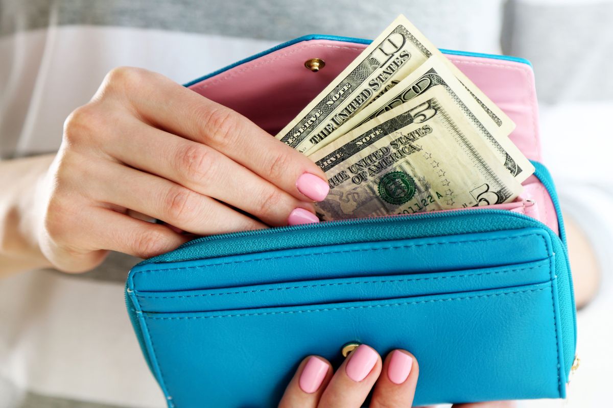 Image of a woman's hand grabbing her cash reserve.