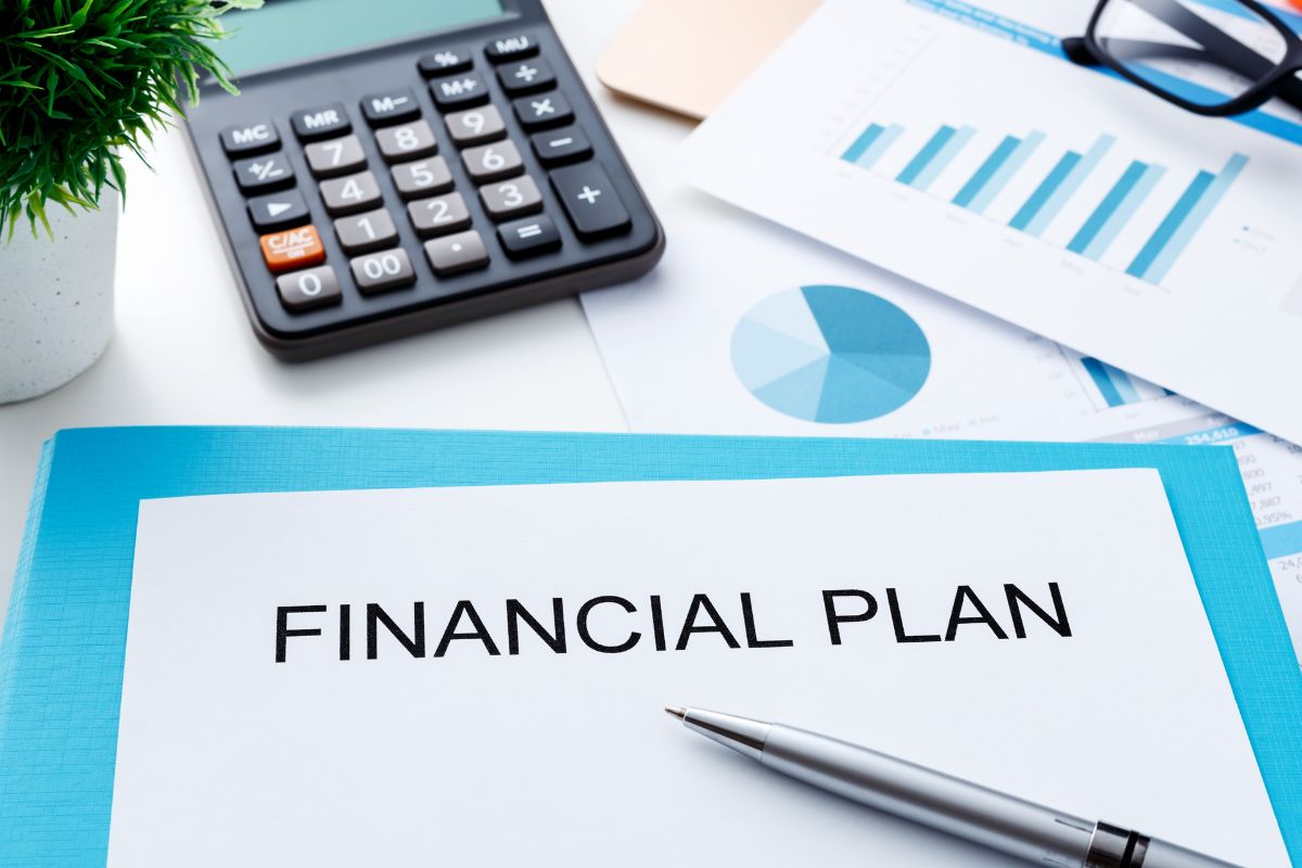 Imagem de uma calculadora e um artigo com redação do plano financeiro.
