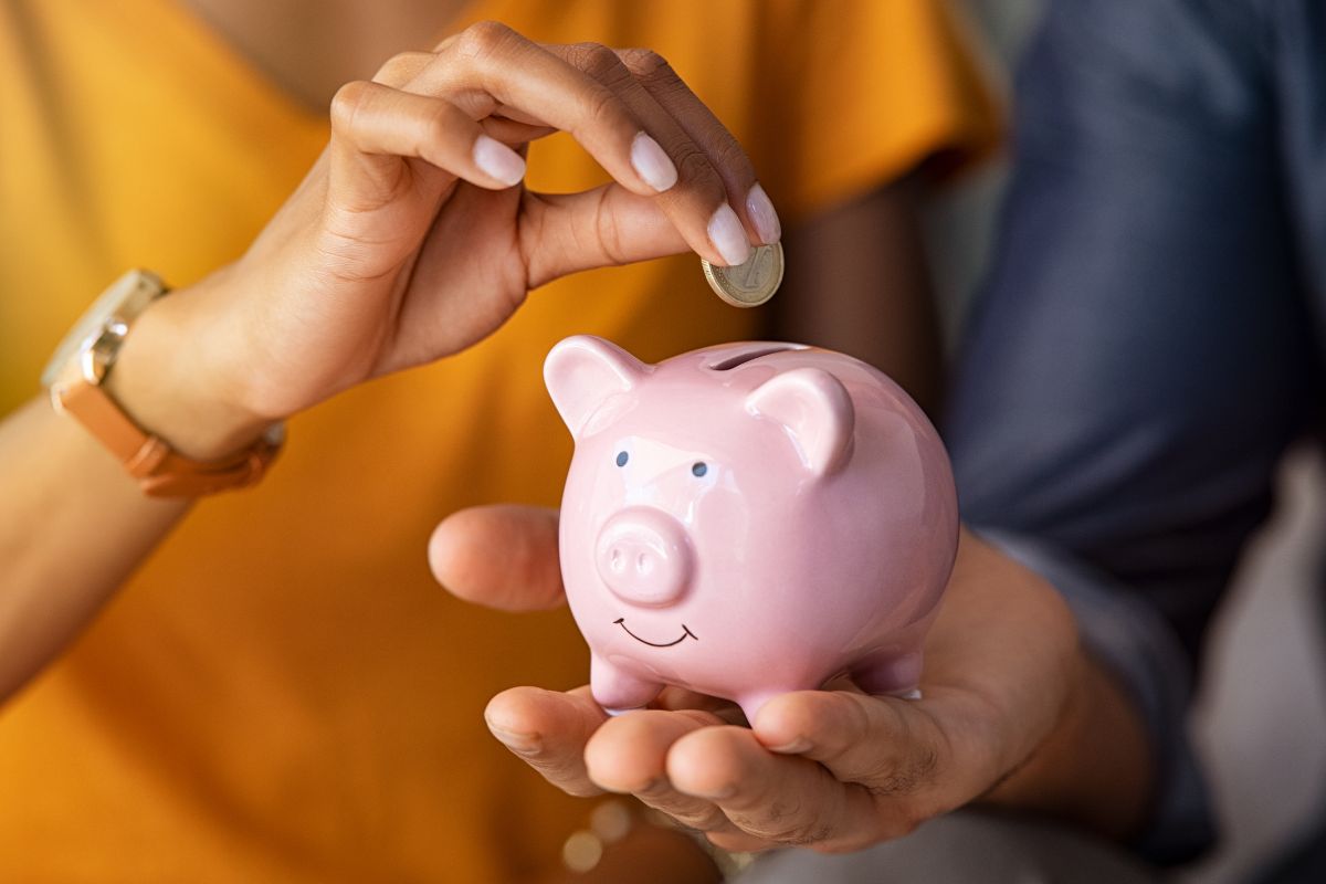 Foto de um casal economizando uma pequena quantia de dinheiro.