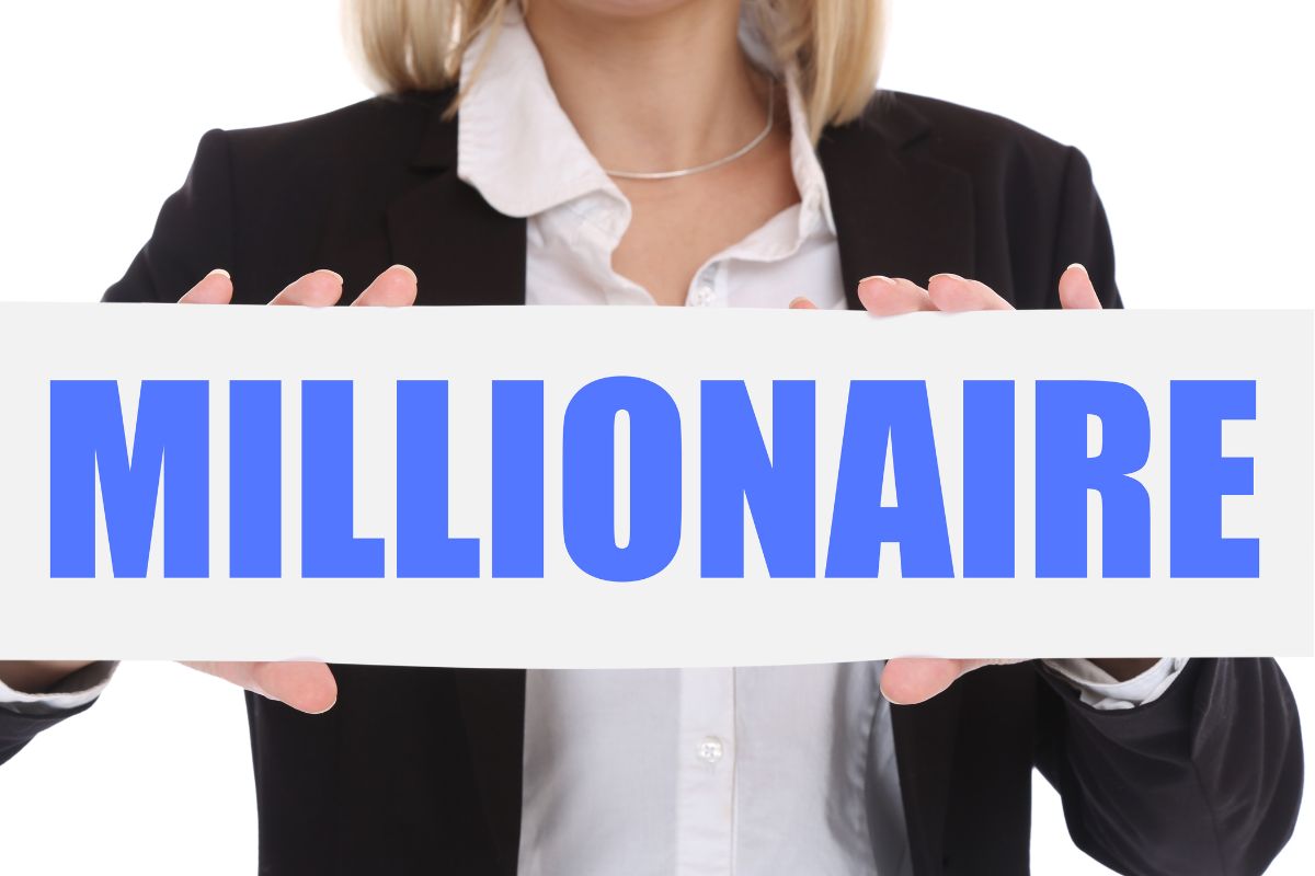 The image shows a woman's hand holding a millionaire signage.