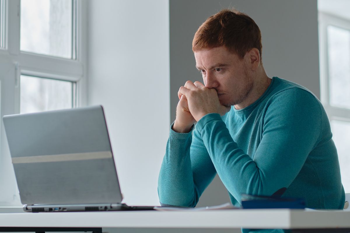 Photo of a man looking at the laptop.