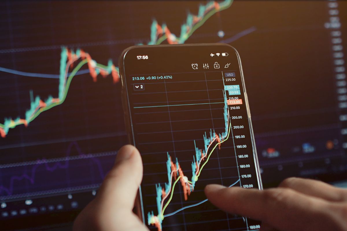 Picture of a man's hand investing in stocks.