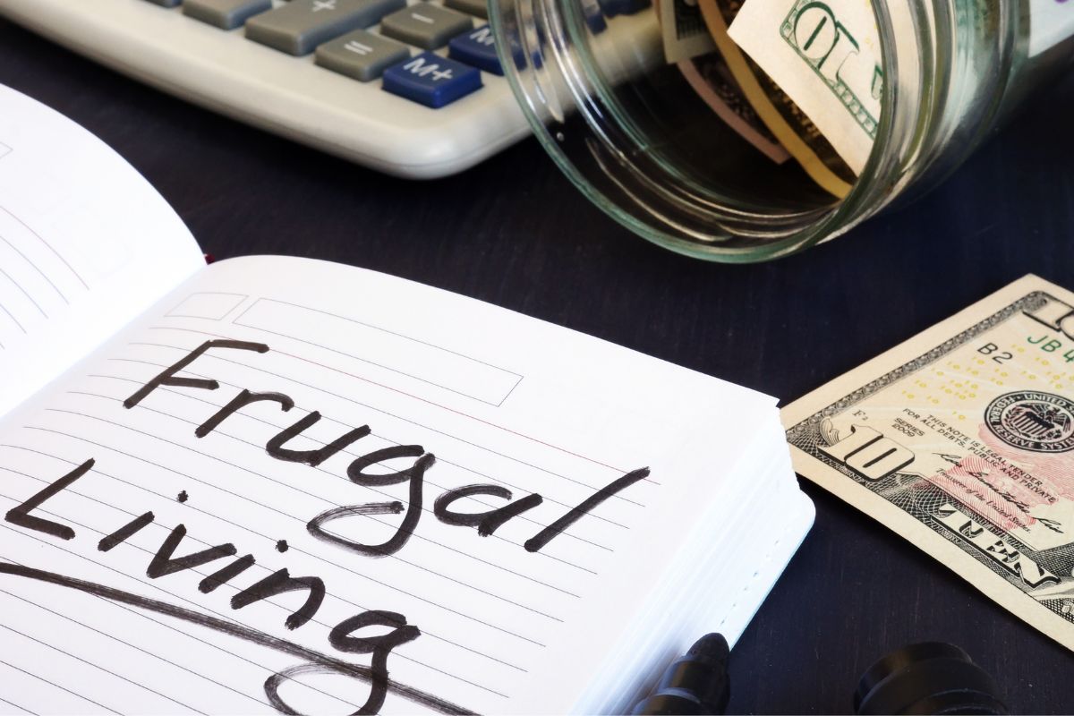 Image of money and a notebook with frugal living wording.