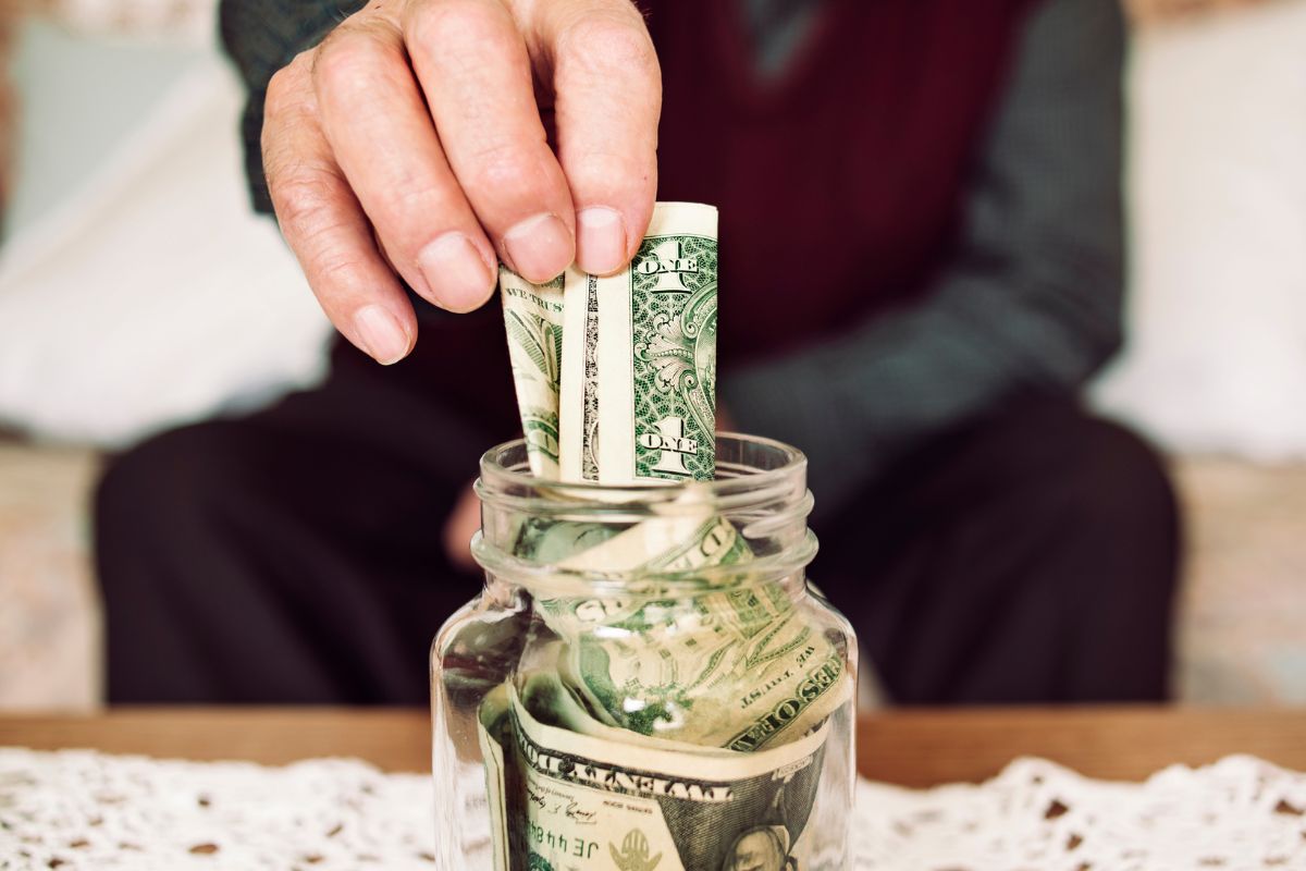 A man's hand saving money.