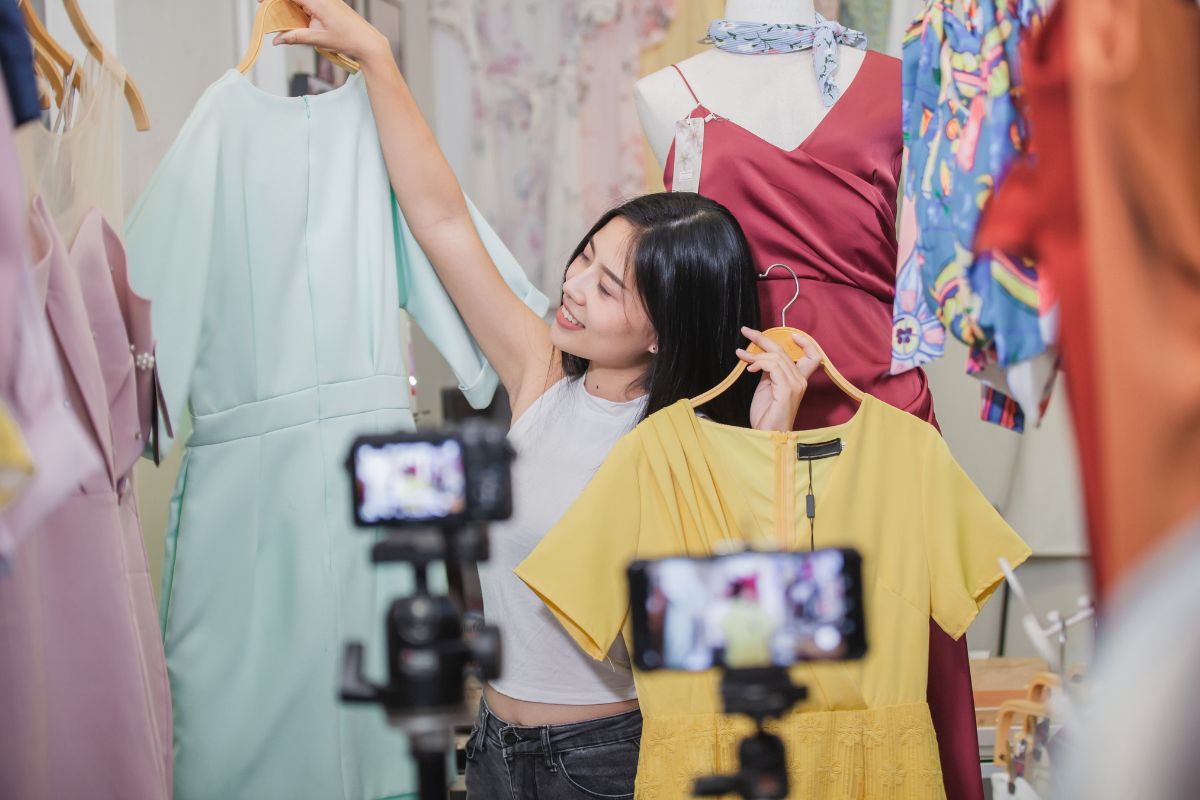 The photo shows a woman live selling clothes.