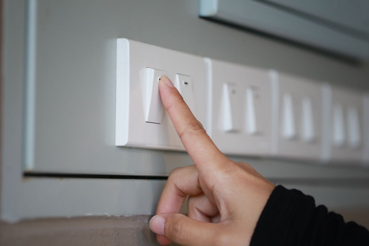 A woman's hand turns off the light.