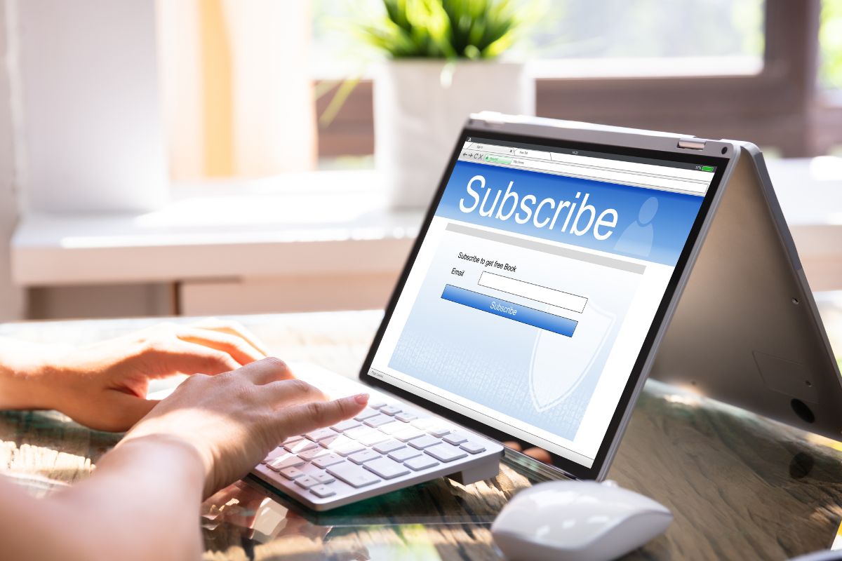 The photo shows a woman using a laptop.