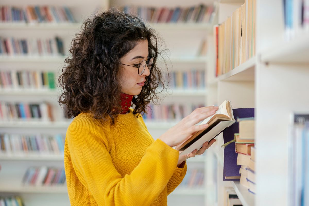 The image shows a woman reading a book.
