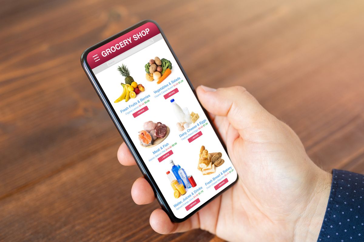 Image a man's hand shopping for groceries online.