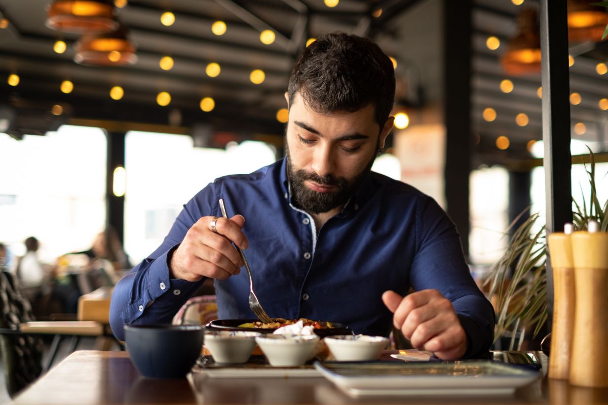 A man is eating at the restaurant.