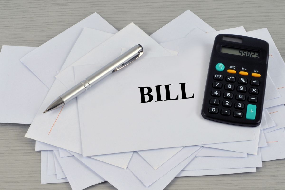 Picture of a calculator and envelopes with bills.
