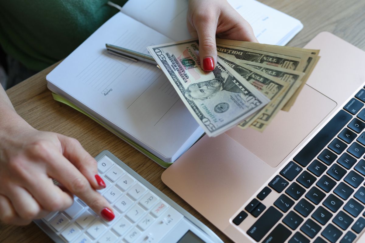A woman's hand checking her income and expenses.