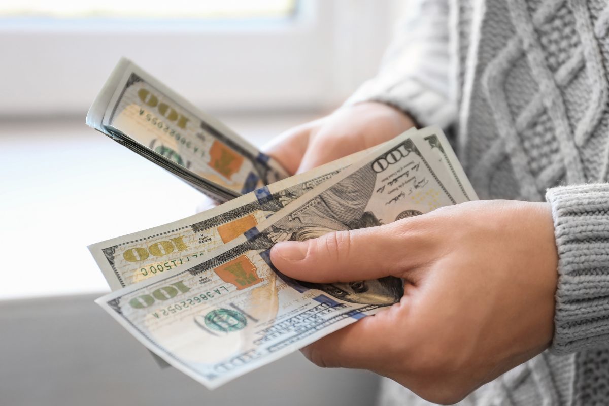 A mão de uma mulher contando dinheiro.