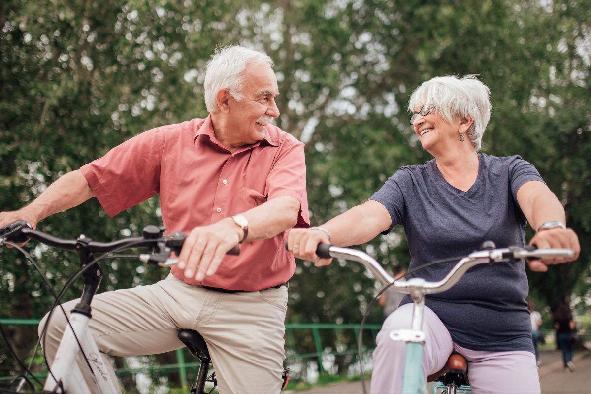 Image d'un couple de seniors à vélo.