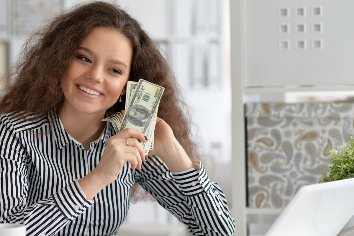 Image of a young woman holding money.