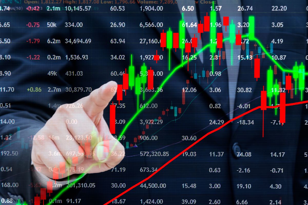A mão de um homem investindo em ações individuais.