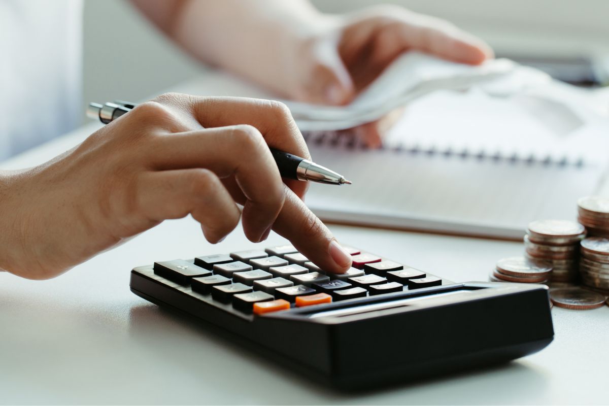 The photo shows a woman's hand budgeting money.