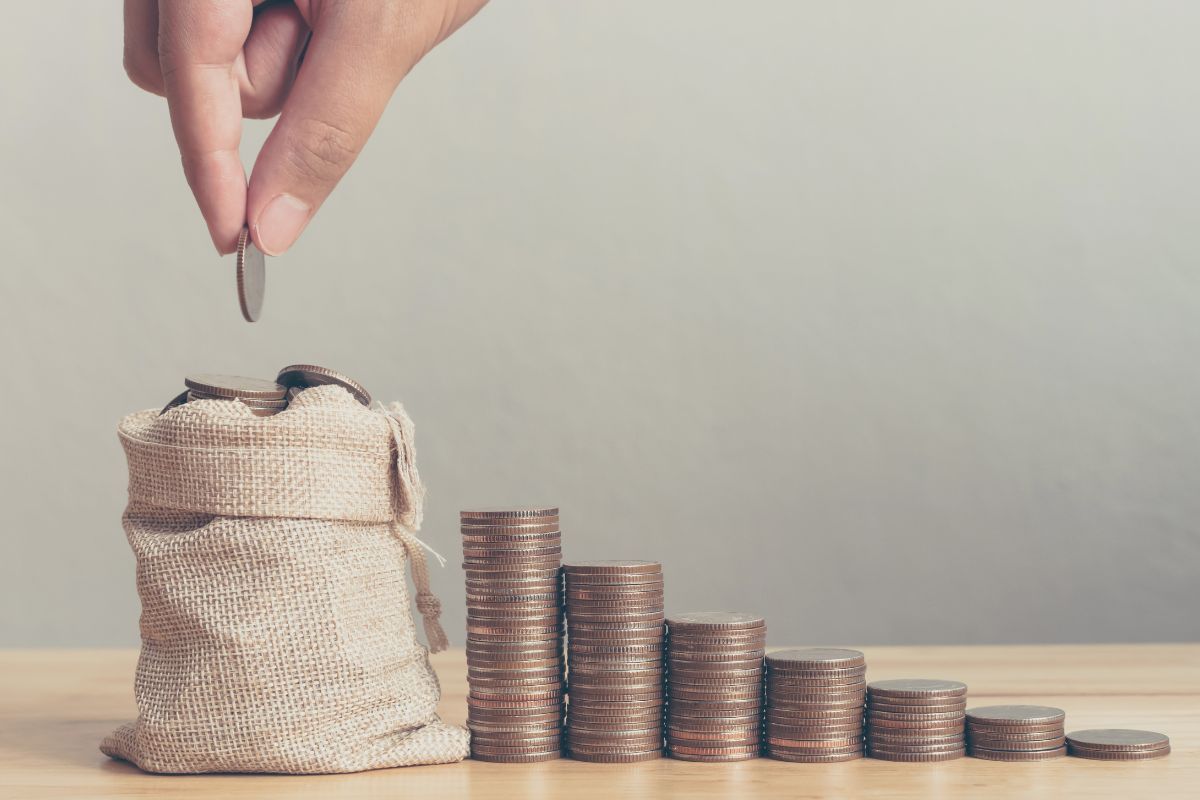 A mão de uma mulher economiza dinheiro.