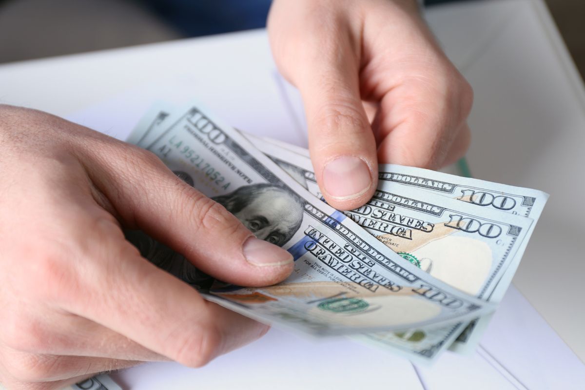 Image of a man's hand counting money.