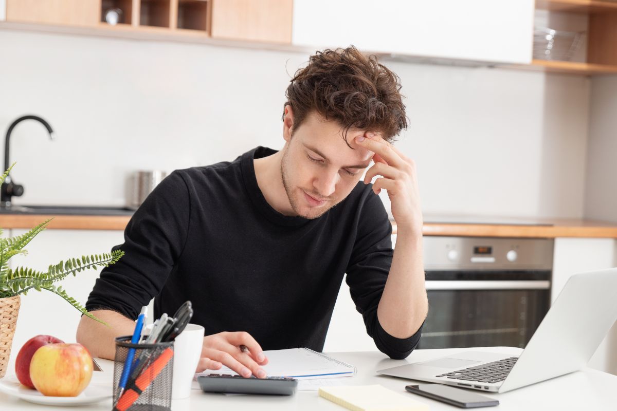 The photo shows a man budgeting.