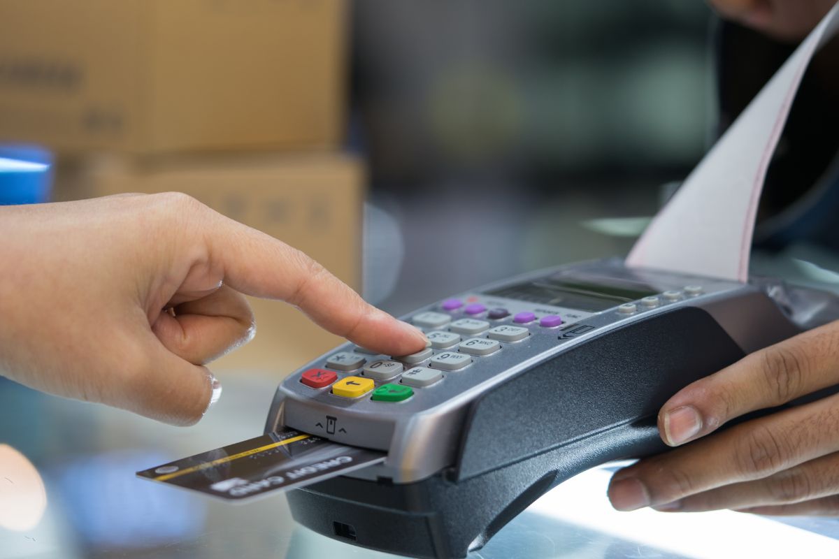 A woman's hand paying with a credit card.