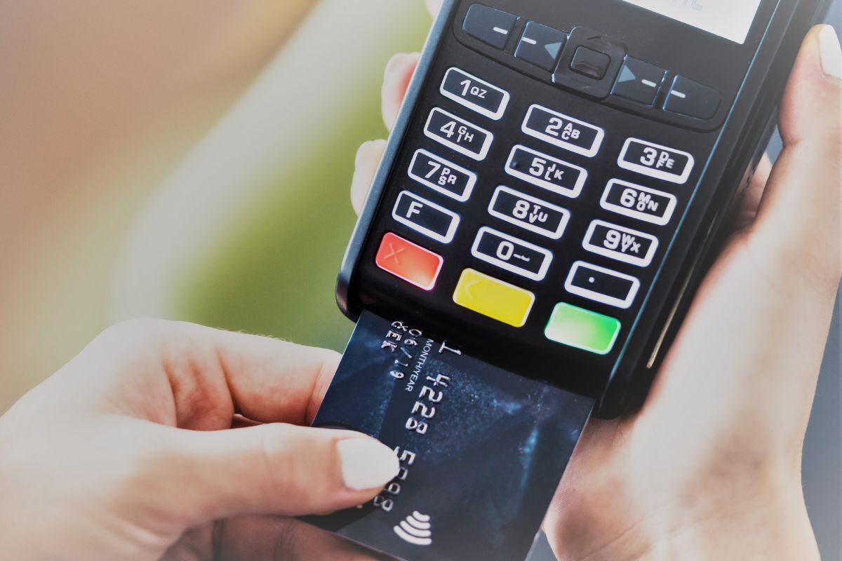 Picture of a woman's hand paying with a credit card.