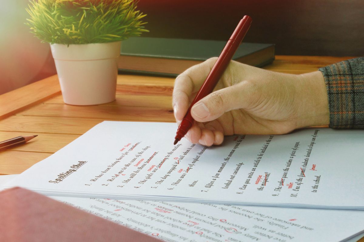 Picture of a man's hand proofreading a paper.