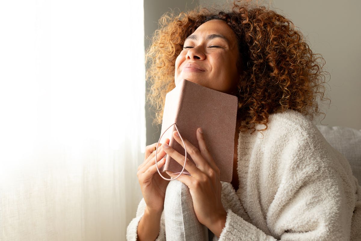 Photo of a woman holding a notebook.