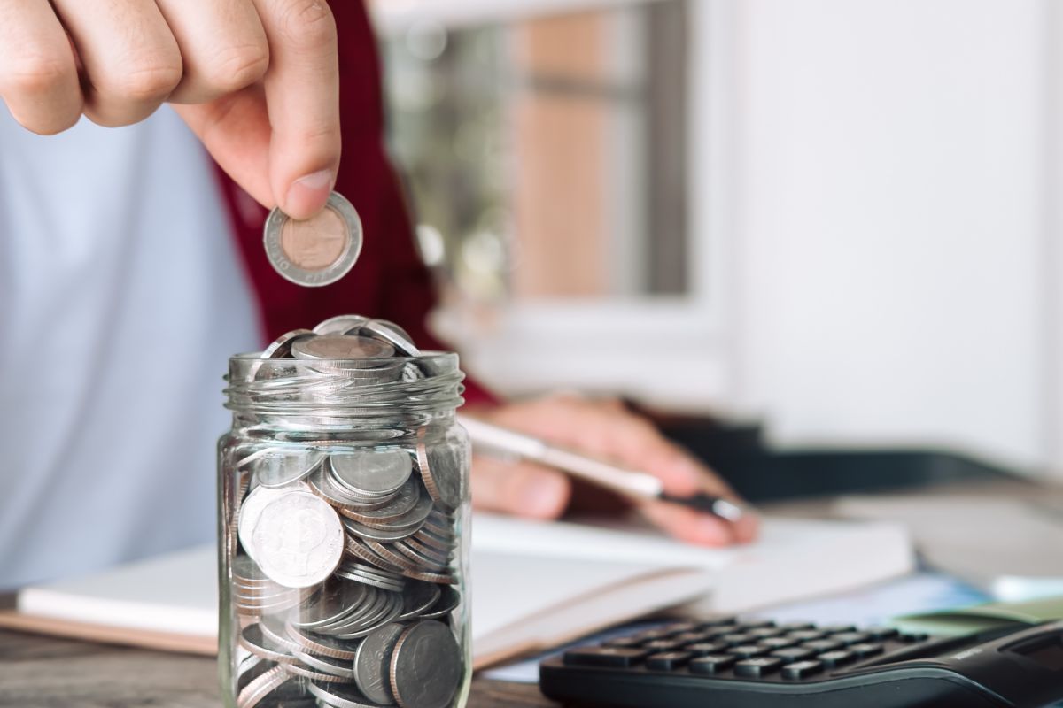 A man's hand savings money.