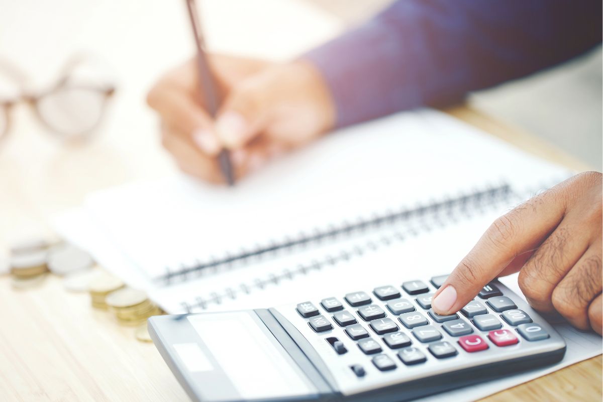 The picture shows a man's hand eliminating extra expenses.