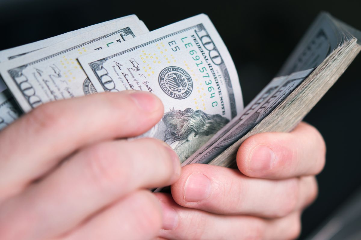 A man's hand counting money.