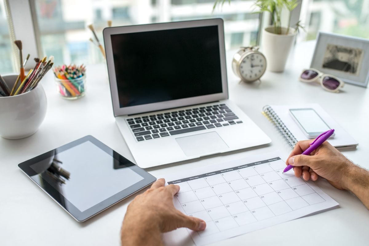 A man's hand creates an action plan.