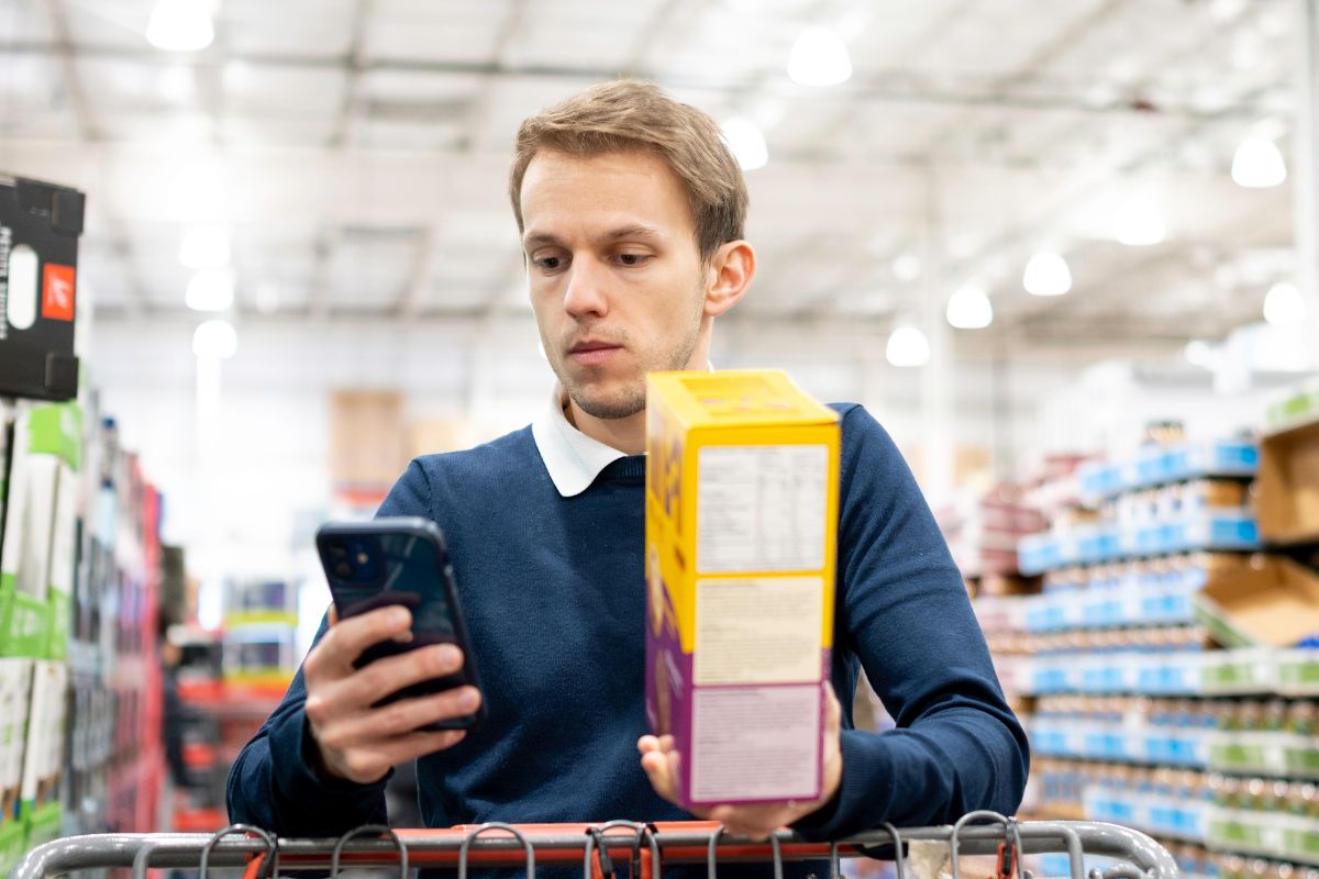 Picture of a man totaling the bill while grocery shopping.