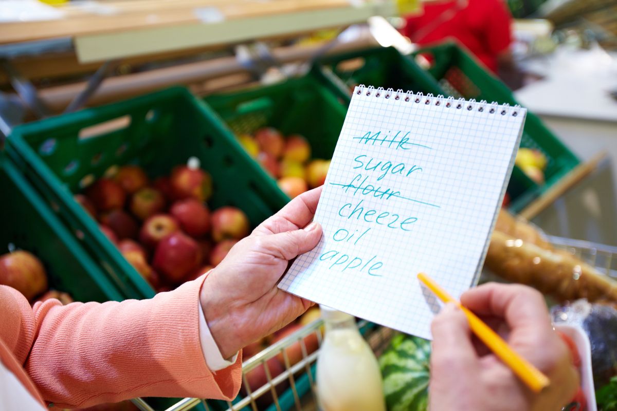 Picture of a woman's hand checking her shopping list.