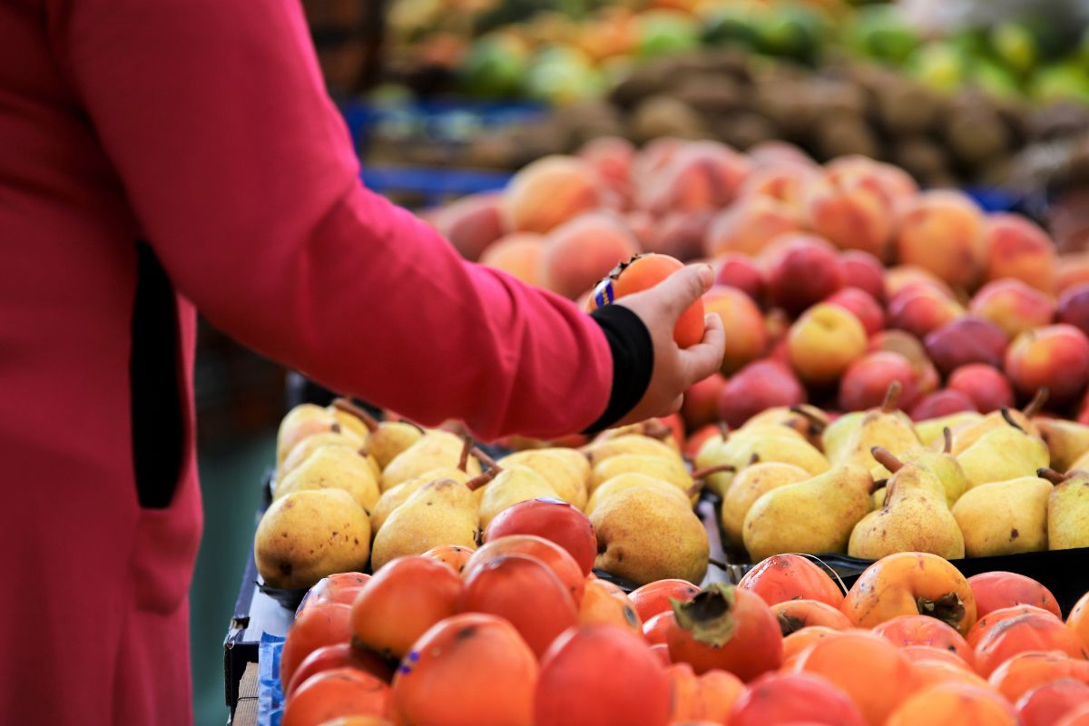 A woman buying seasonal fruits.