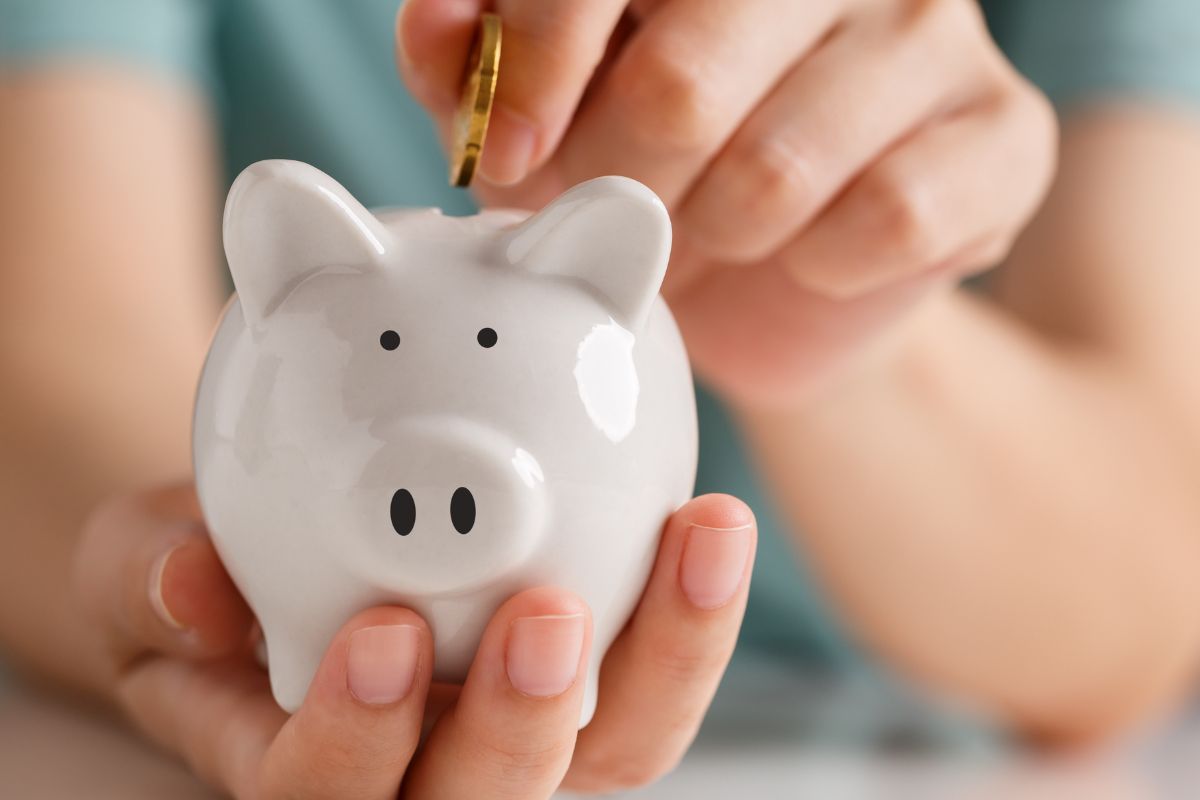 A man's hand saving money.