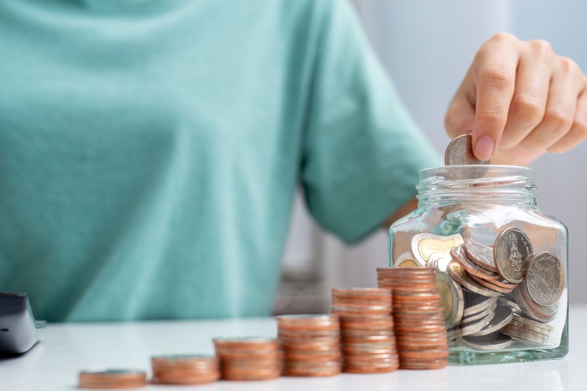 A woman's hand saving money.