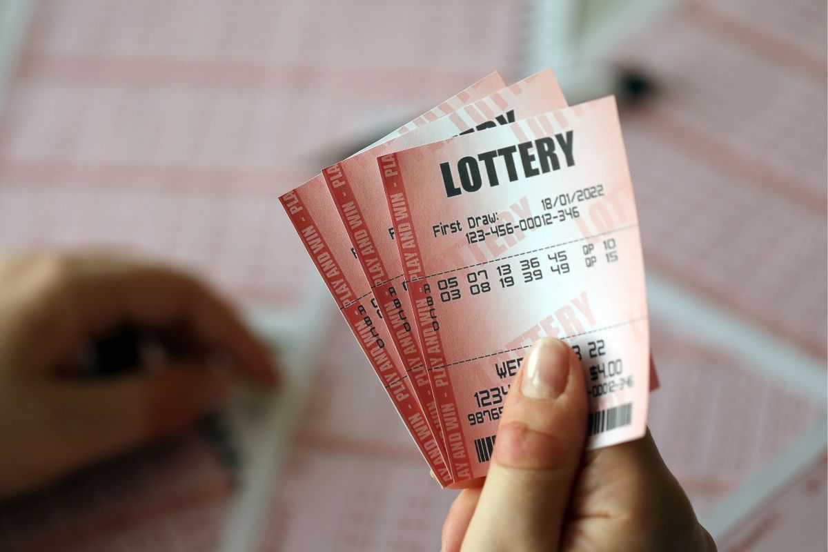 Picture of a woman's hand holding lottery tickets.