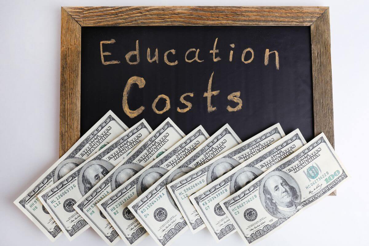 The image of dollar bills and board with a text indicating setting aside money for education costs to help handle school fees and other related expenses.