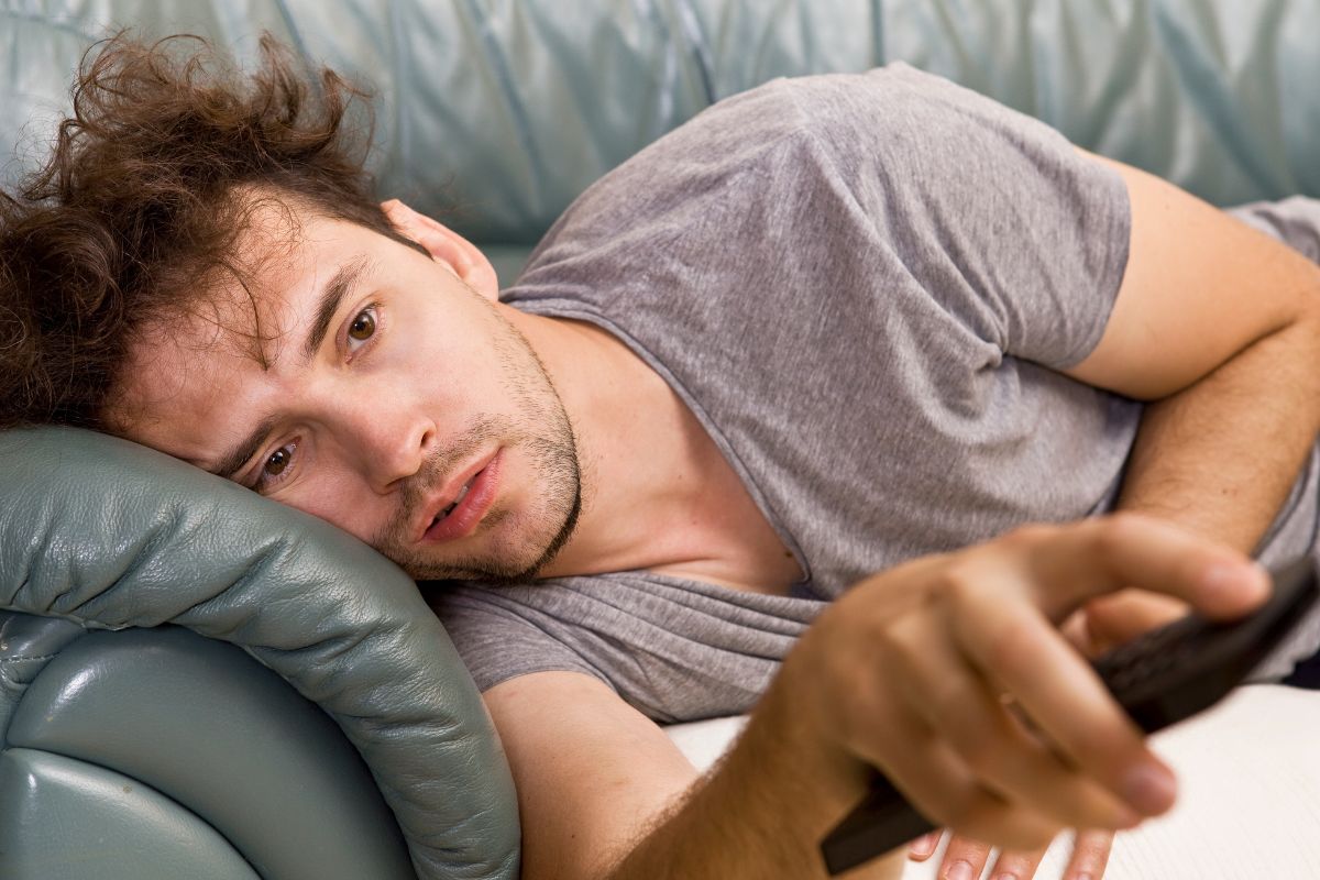 Picture of a lazy man watching a TV.