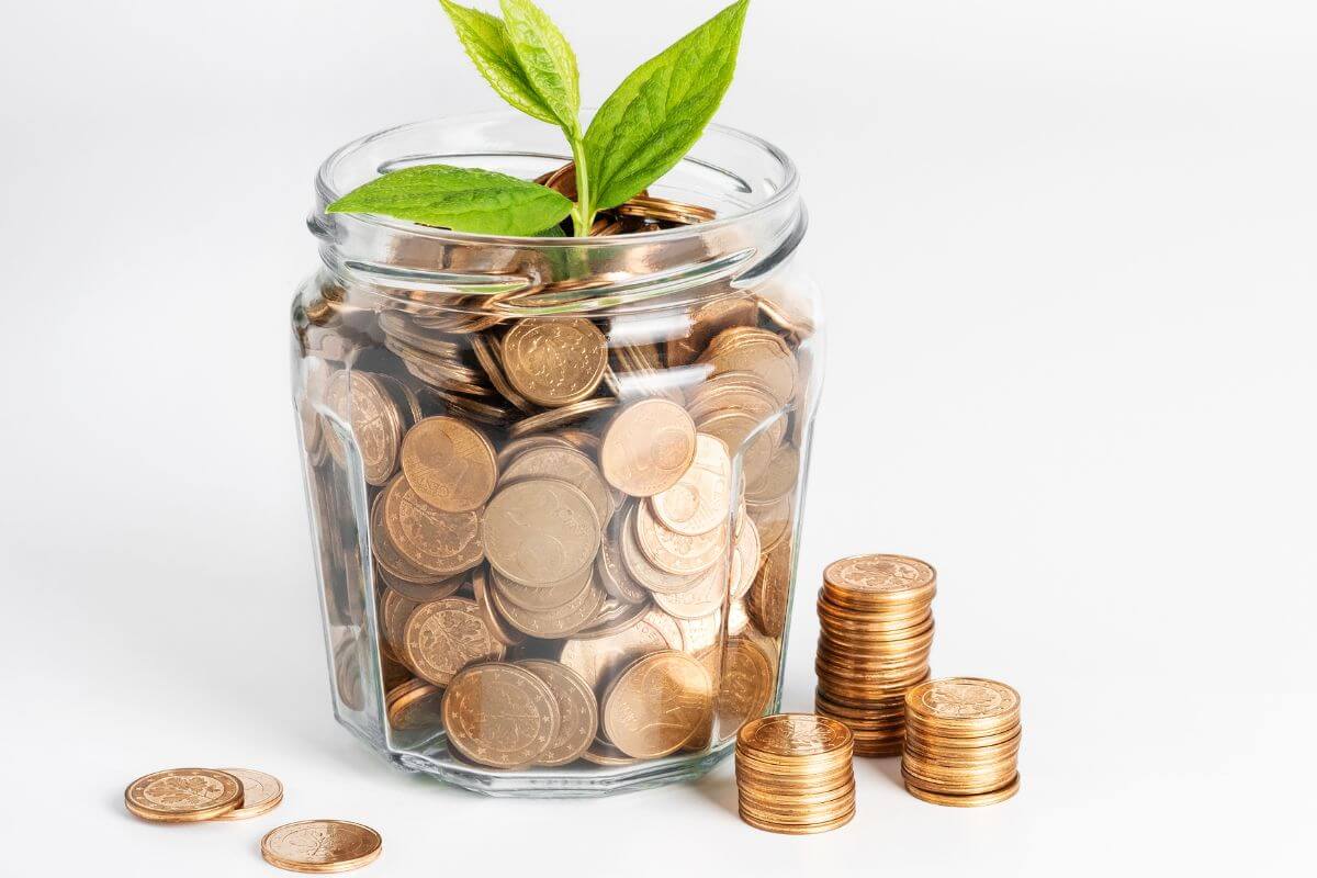 The picture shows the coins in a jar to check if you have sinking funds covered with these useful ideas.