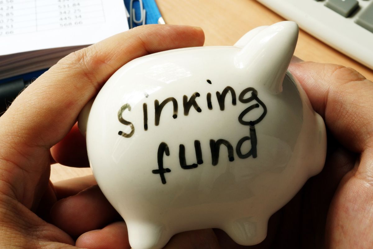 A man's hand holding a sinking fund.